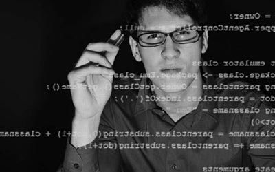 A penetration tester with glasses examining line of code during a code review